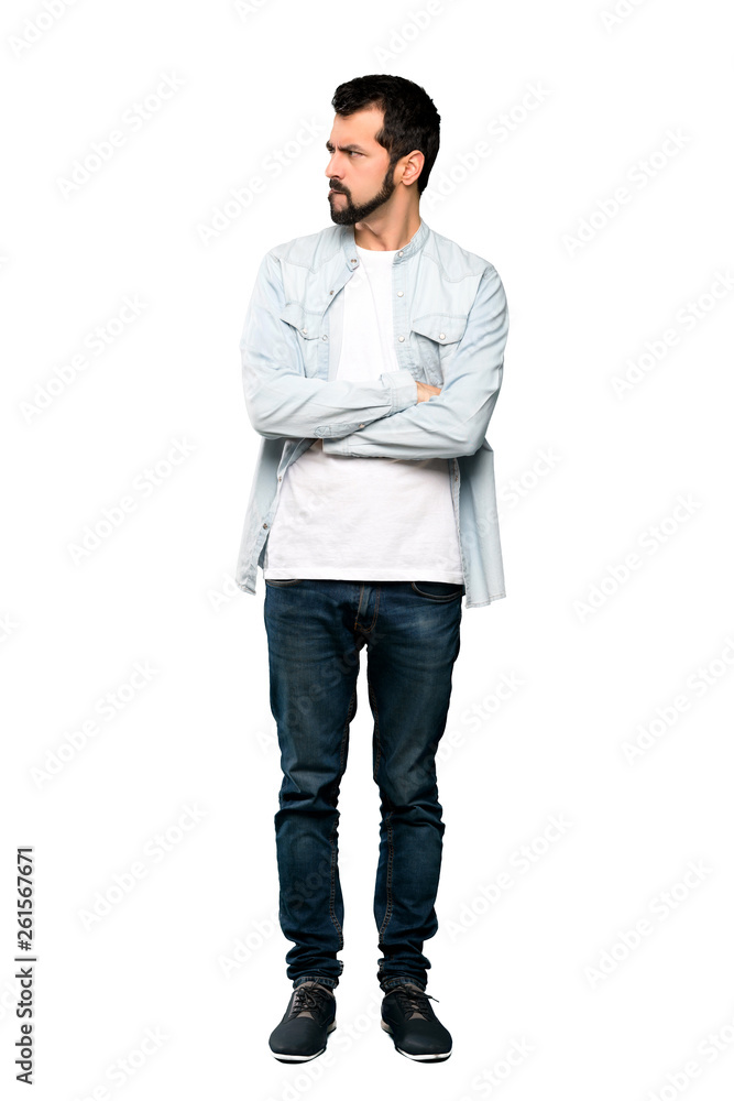 Fototapeta premium Full-length shot of Handsome man with beard with confuse face expression over isolated white background
