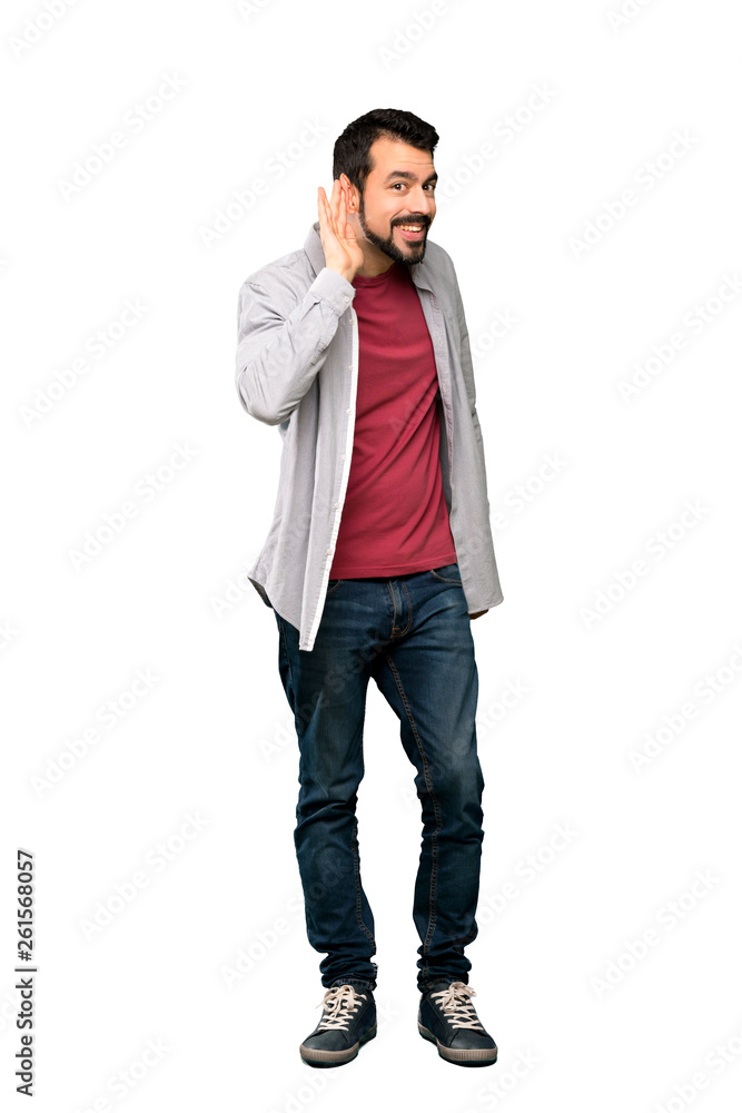 Full-length shot of Handsome man with beard listening to something by putting hand on the ear over isolated white background Full-length shot of Handsome man with beard listening to something by putting hand on the ear over isolated white background