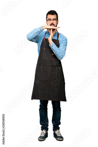 Full-length shot of Man with apron making time out gesture over isolated white background