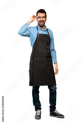 Full-length shot of Man with apron with glasses and surprised over isolated white background © luismolinero