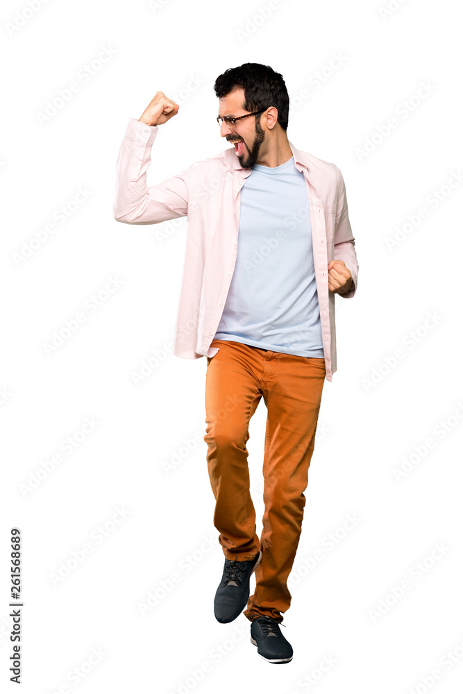 Fototapeta premium Full-length shot of Handsome man with beard celebrating a victory over isolated white background