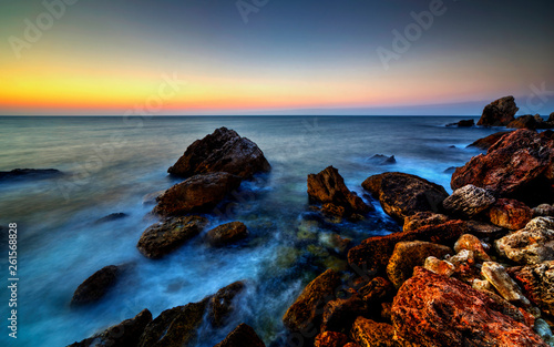 Beautiful sunrise over rocky shore © phadventure
