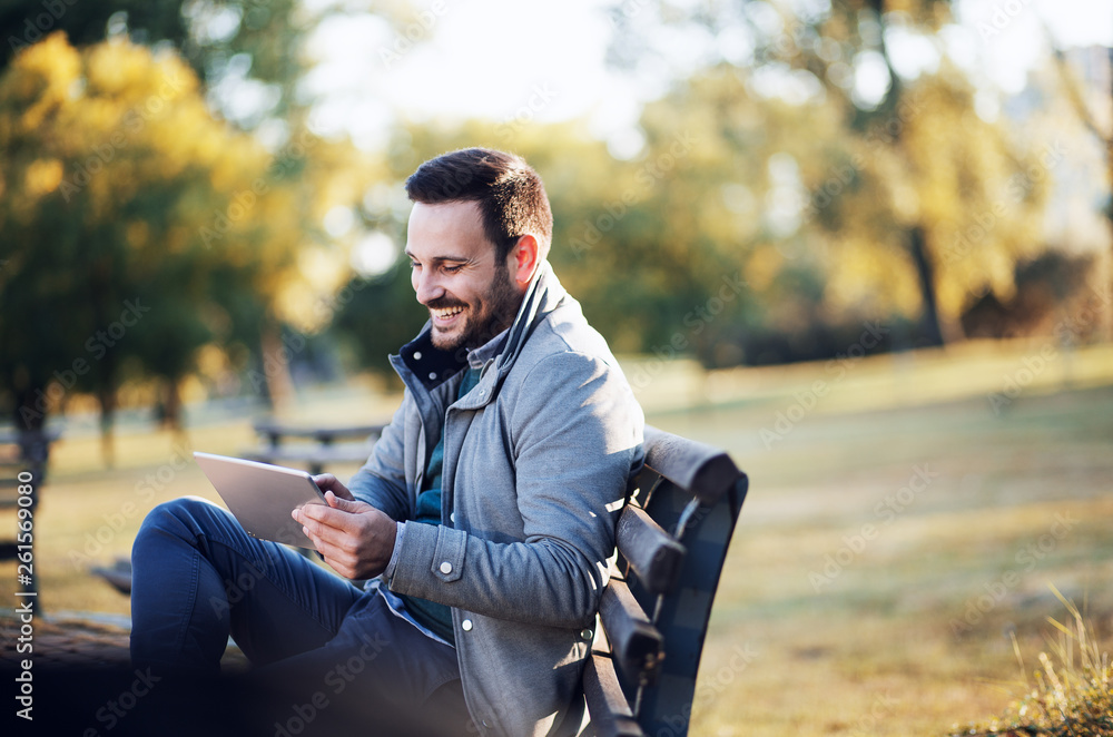 Casual Businessman sitting on bench and using tablet Casual Businessman sitting on bench and using tablet