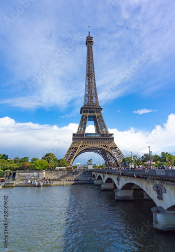 Eiffel Tower with view of Seine river and the bridge in cloudy blue sky day in Paris, France © Jphoto4956
