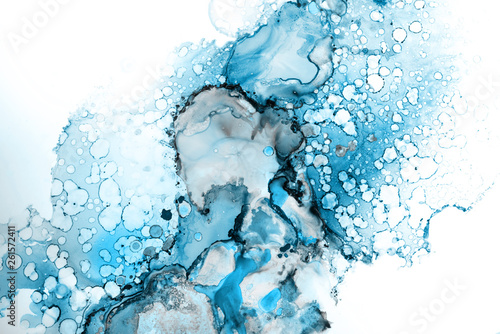 Blue alcohol ink texture with abstract washes and paint stains on the white paper background. 