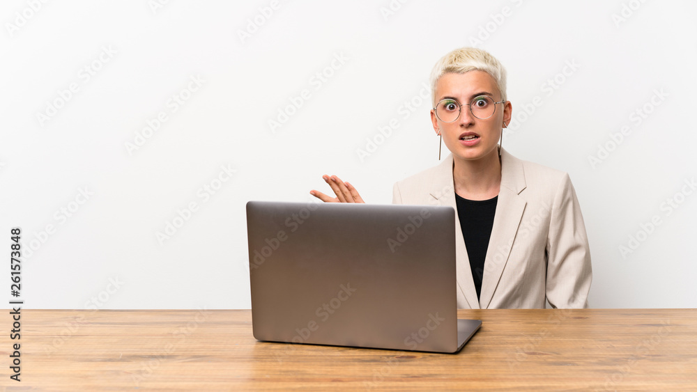 Teenager girl with short hair with a laptop making doubts gesture Teenager girl with short hair with a laptop making doubts gesture