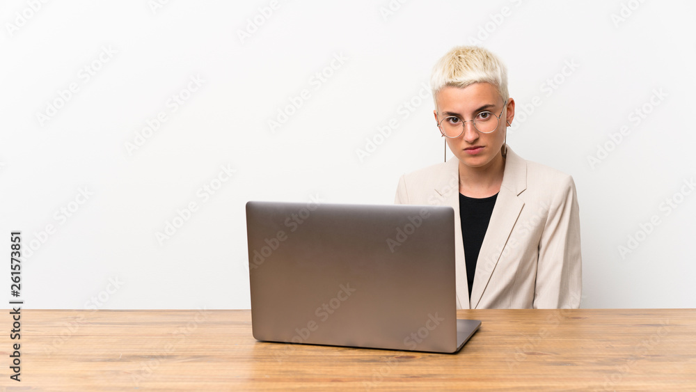 Teenager girl with short hair with a laptop with sad and depressed expression Teenager girl with short hair with a laptop with sad and depressed expression