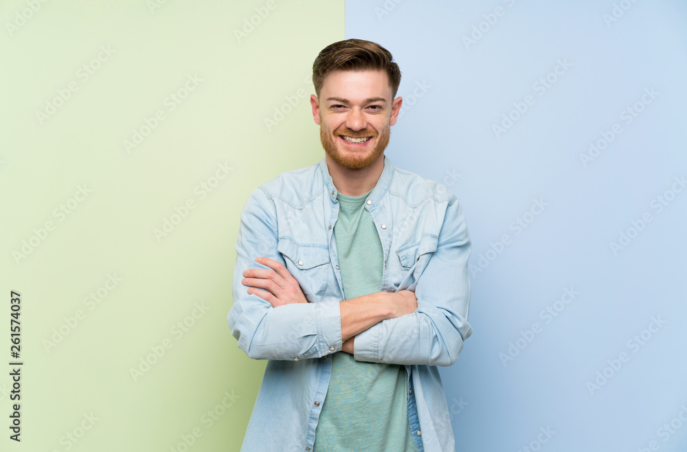 Redhead man over colorful background keeping the arms crossed in frontal position Redhead man over colorful background keeping the arms crossed in frontal position
