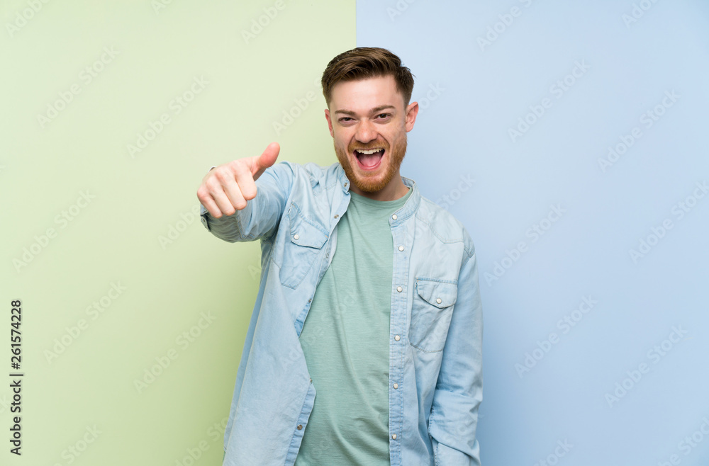 Redhead man over colorful background with thumbs up because something good has happened Redhead man over colorful background with thumbs up because something good has happened