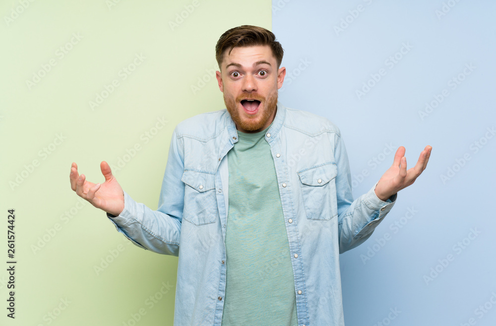 Redhead man over colorful background with shocked facial expression Redhead man over colorful background with shocked facial expression
