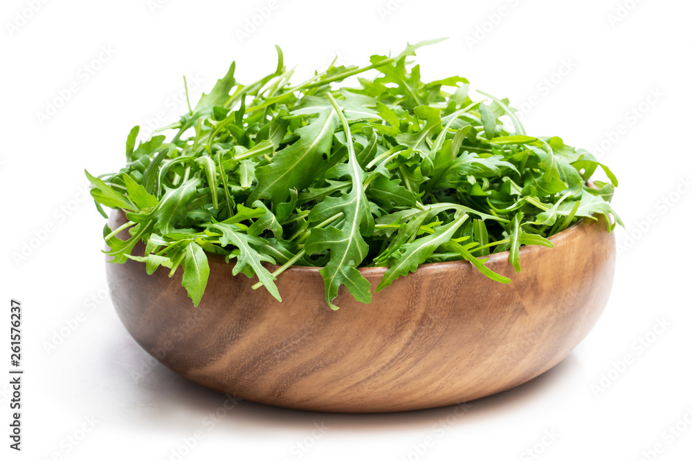 Rocket salad leaves in wooden bowl isolated on white Rocket salad leaves in wooden bowl isolated on white