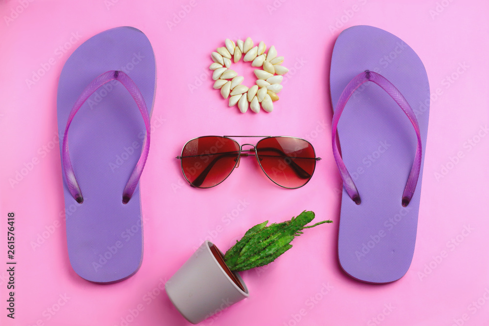 Beach purple beach flip flops, aviator sunglasses, seashell bracelet and succulent cacti cactus on a pink background. Summer colorful  travel beach flat lay