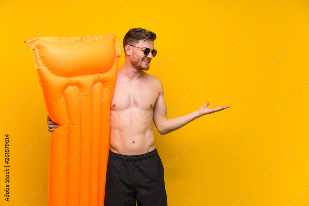 Redhead man in summer holidays extending hands to the side for inviting to come Redhead man in summer holidays extending hands to the side for inviting to come