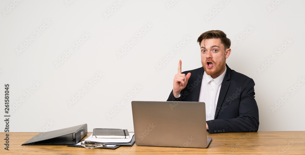 Businessman in a office thinking an idea pointing the finger up Businessman in a office thinking an idea pointing the finger up