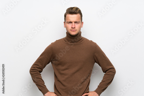 Blonde man over isolated white wall angry