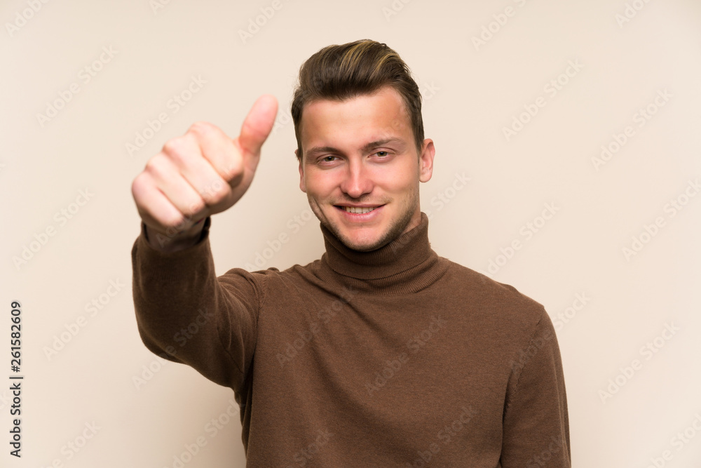 Blonde handsome man over isolated wall giving a thumbs up gesture Blonde handsome man over isolated wall giving a thumbs up gesture