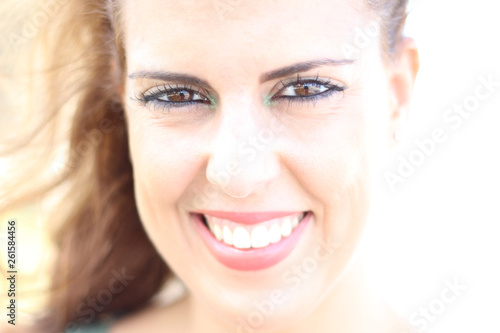 High key portrait of brunette young woman smiling on a sunny day. photo