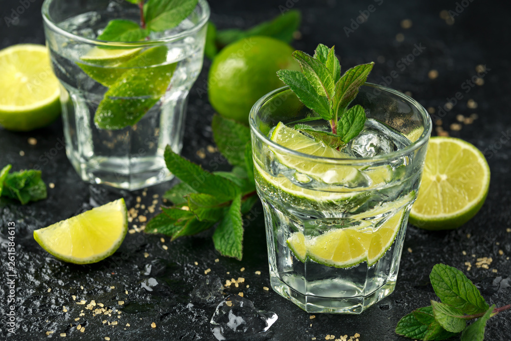 Mojito cocktail with Rum, lime and mint in glass. Summer cold drink with ice Mojito cocktail with Rum, lime and mint in glass. Summer cold drink with ice