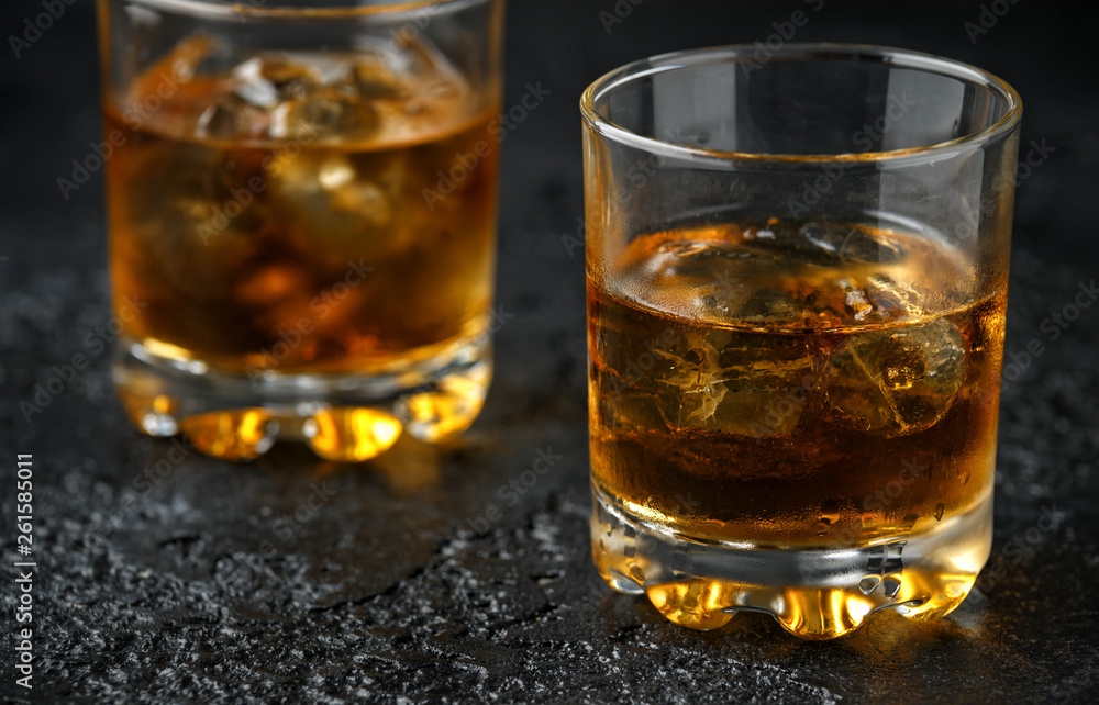 Glass of whiskey with ice on rustic background Glass of whiskey with ice on rustic background