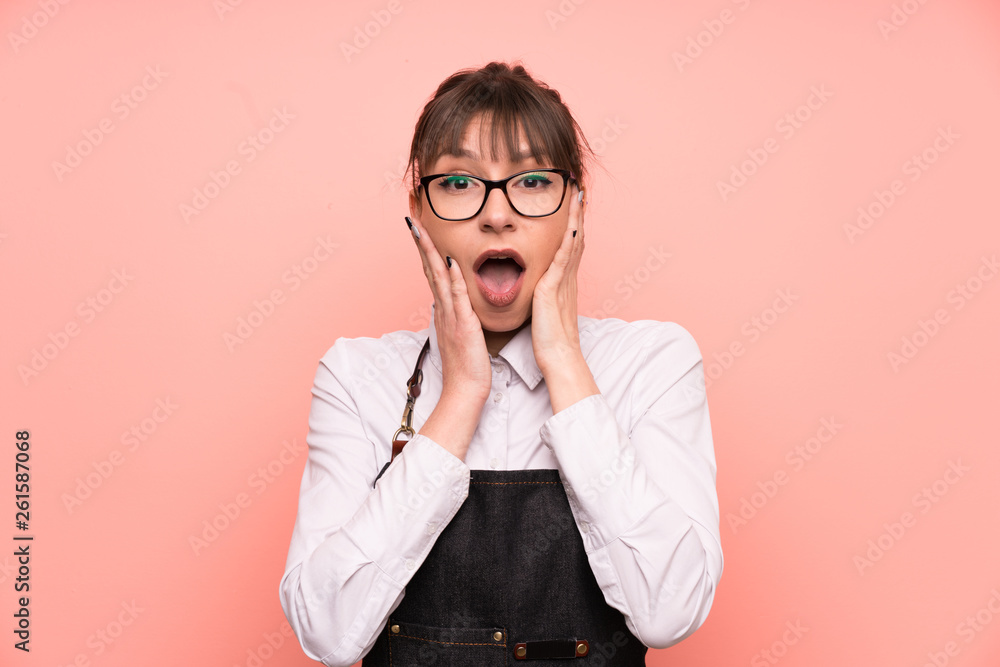 Young waitress over pink background with surprise facial expression