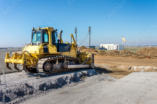 Construction site of road, building or airport with construction machinery (truck, bulldozer, dozer, excavator) and construction workers or engineers