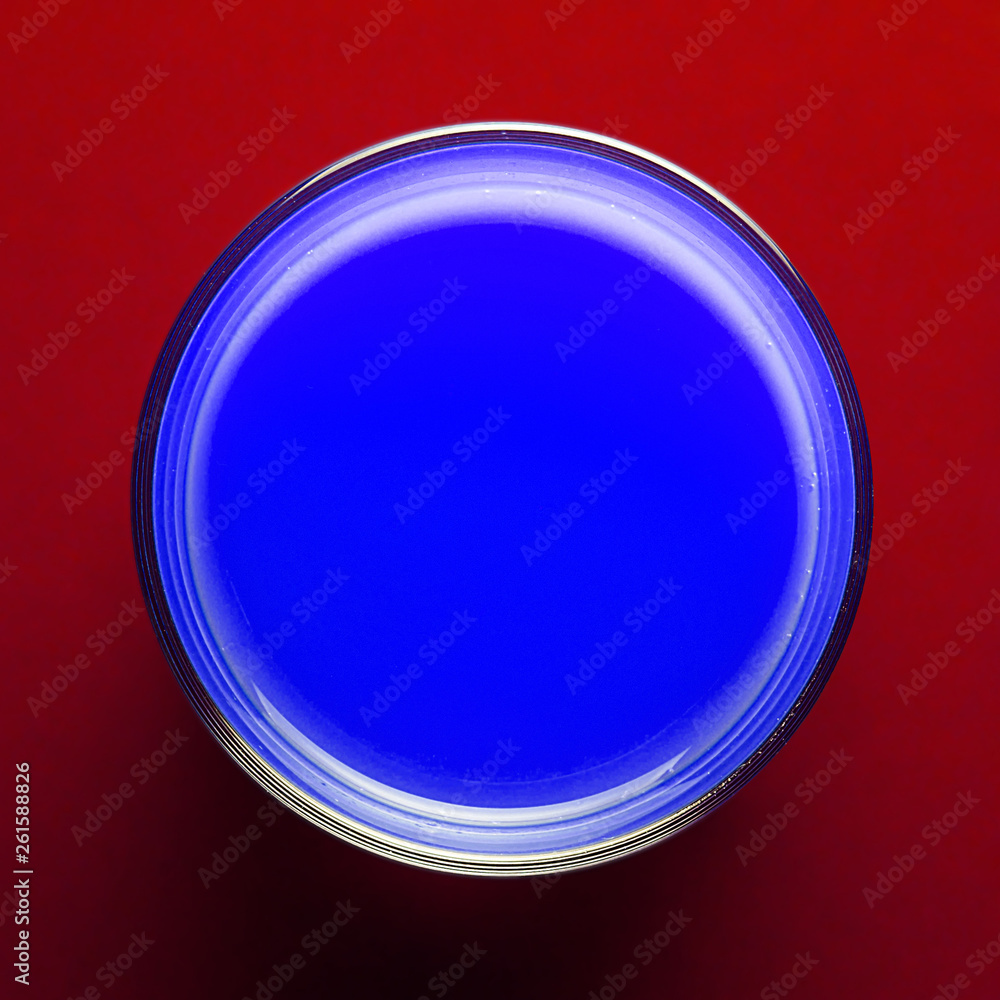 Creative template glass with blue paint on colored red paper.