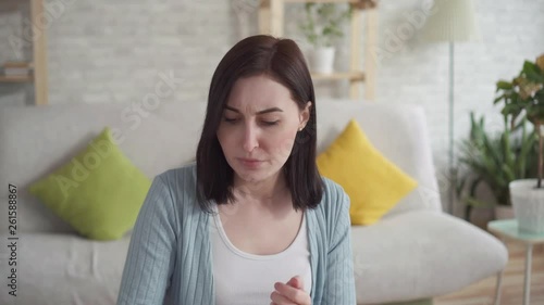 Close up of a young woman smears chapped lips healing balm sitting