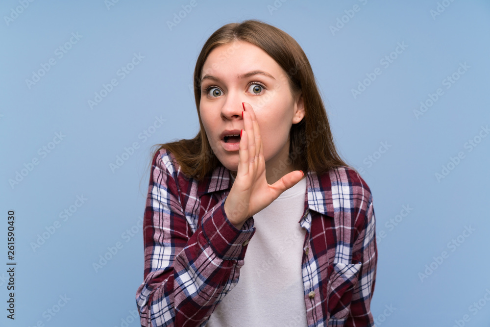 Young woman over blue wall whispering something Young woman over blue wall whispering something