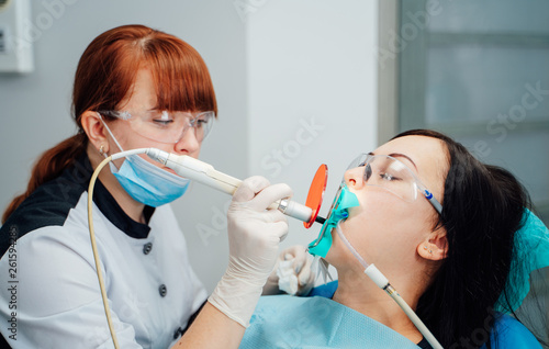 Female dentist treating patient woman teeth