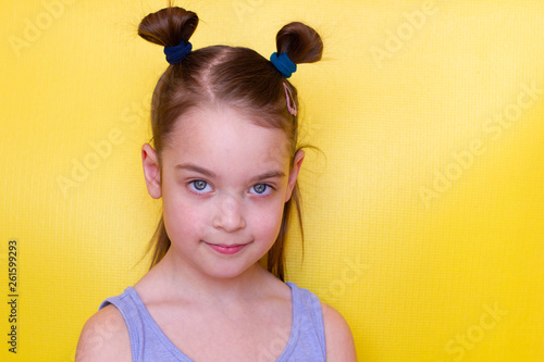 Fotografie Cute little girl on a yellow background