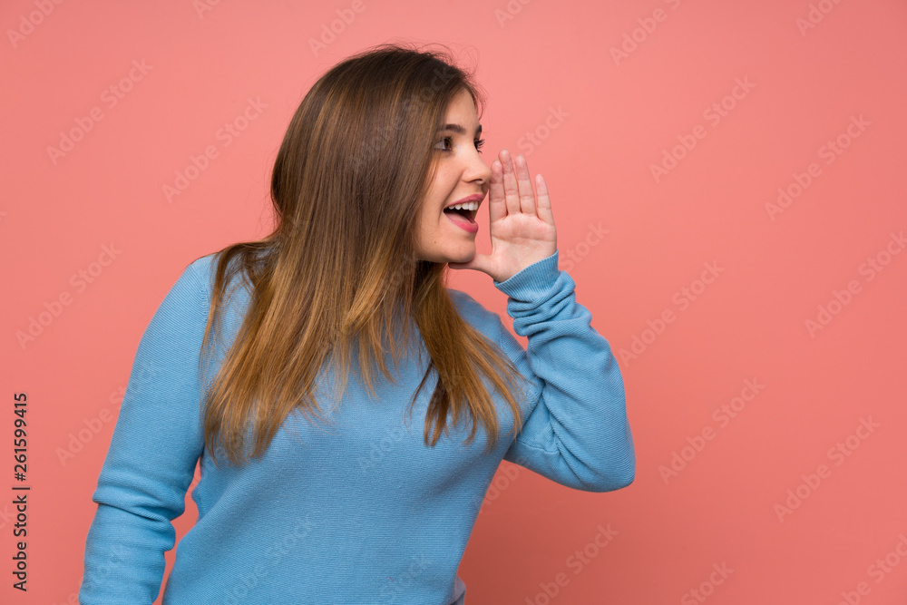 Young girl with blue sweater shouting with mouth wide open Young girl with blue sweater shouting with mouth wide open