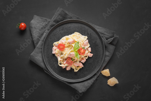 Pasta tagliatelle with trout and cream on black background. Delicious Mediterranean lunch.
