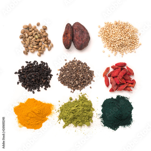 Small heap of various superfoods on white background.Superfood as chia,spirulina,matcha tea powder,raw cocoa bean,goji berry,hemp,quinoa,black sesame,turmeric.Top view.Isolated on white,clipping path