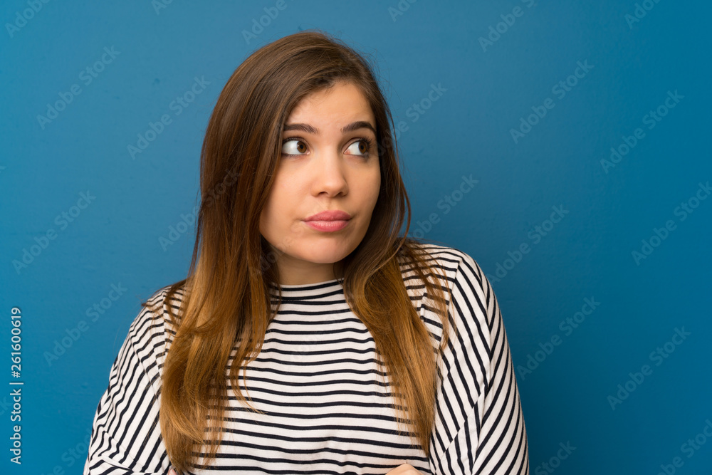 Young girl with striped shirt standing and thinking an idea Young girl with striped shirt standing and thinking an idea