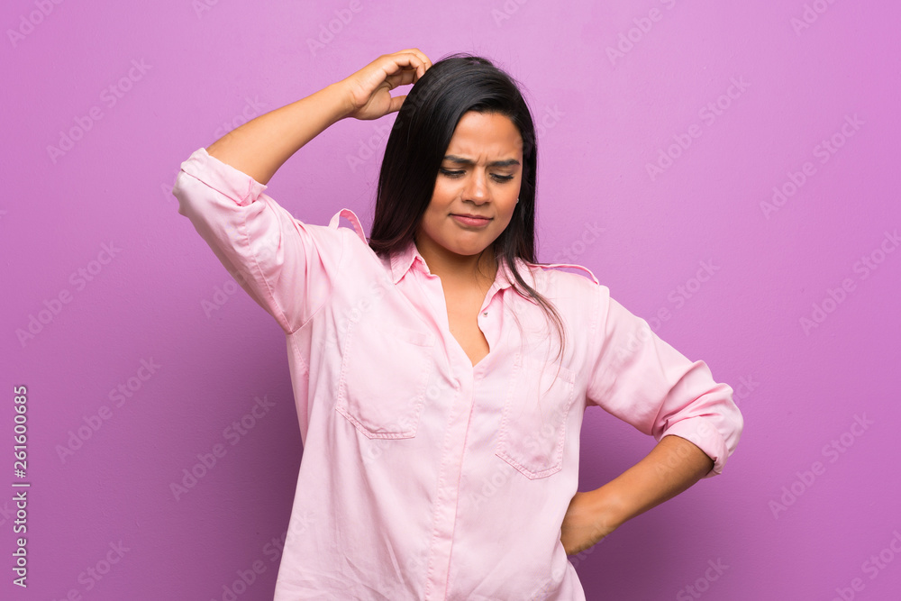 Young Colombian girl over purple wall having doubts while scratching head Young Colombian girl over purple wall having doubts while scratching head