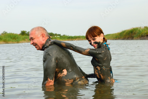 The girl covers the man with mud