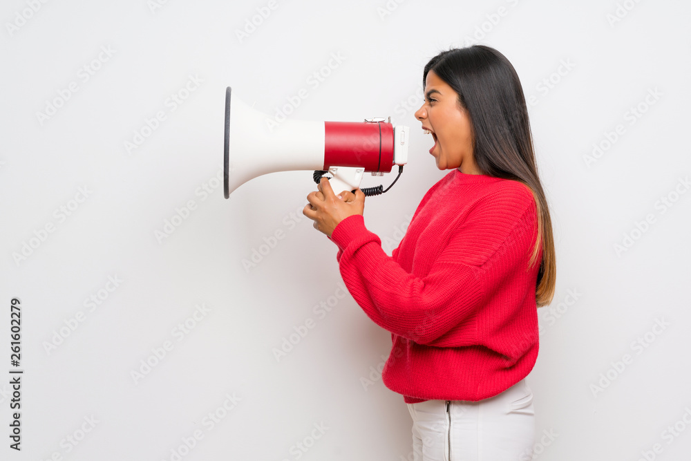 Young Colombian girl with red sweater shouting through a megaphone Young Colombian girl with red sweater shouting through a megaphone