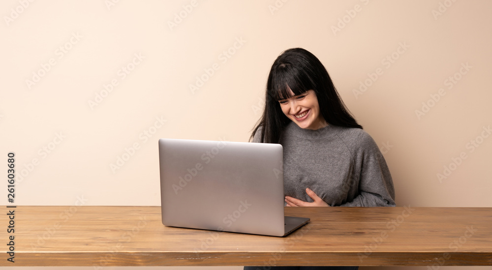Young woman working with her laptop smiling a lot Young woman working with her laptop smiling a lot
