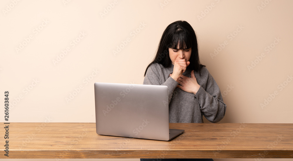 Young woman working with her laptop is suffering with cough and feeling bad Young woman working with her laptop is suffering with cough and feeling bad