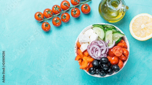 Greek Salad Bowl on blue background, copy space. Above view of Bowl Greek Salad. Trendy food. Idea, recept and concept of modern healthy food. Banner photo