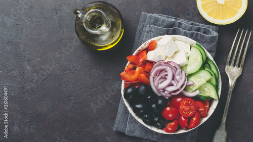 Greek Salad Bowl on dark black background, copy space. Above view of Bowl Greek Salad. Trendy food. Idea, recept and concept of modern healthy food. Banner photo