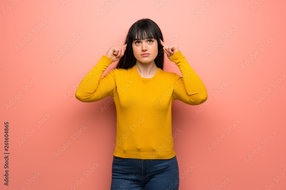 Woman with yellow sweater over pink wall having doubts and thinking Woman with yellow sweater over pink wall having doubts and thinking