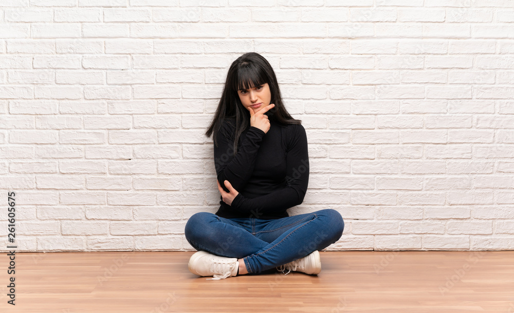 Woman sitting on the floor thinking Woman sitting on the floor thinking