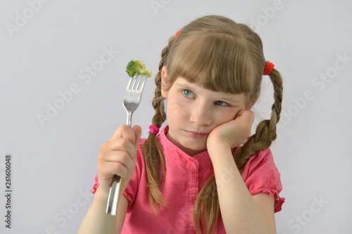 little girl does not want to eat broccoli photo