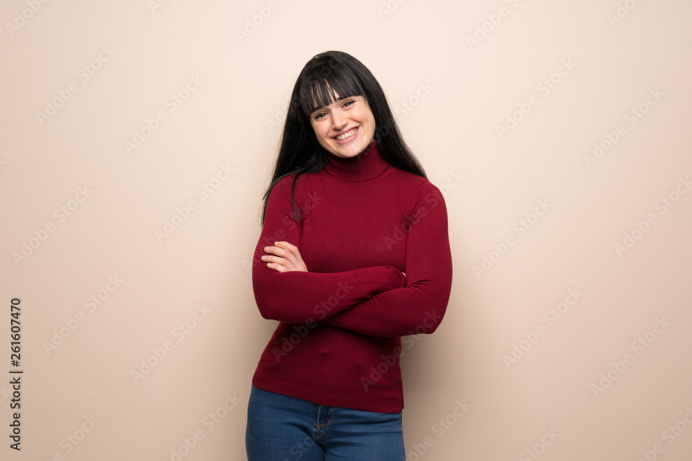 Young woman with red turtleneck keeping the arms crossed in frontal position Young woman with red turtleneck keeping the arms crossed in frontal position