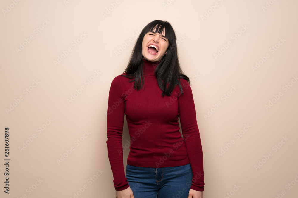 Young woman with red turtleneck shouting to the front with mouth wide open Young woman with red turtleneck shouting to the front with mouth wide open