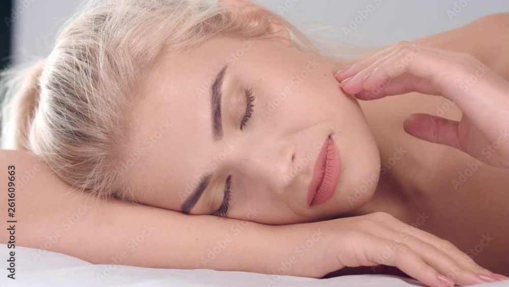 Blonde woman touch her smooth skin with closed eyes Blonde woman touch her smooth skin with closed eyes