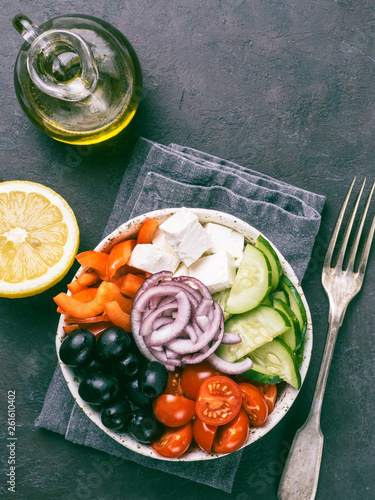 Greek Salad Bowl on dark black background. Above view of Bowl Greek Salad. Trendy food. Idea, recept and concept of modern healthy food. Vertical. Copy space for text. photo