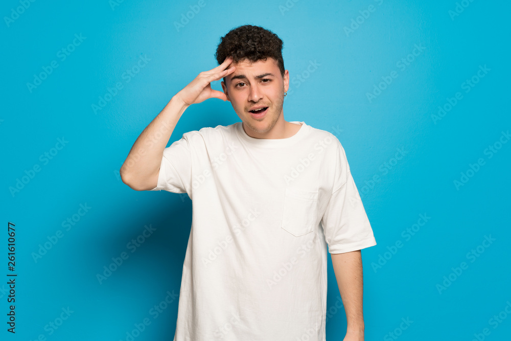 Young man over blue background has just realized something and has intending the solution
