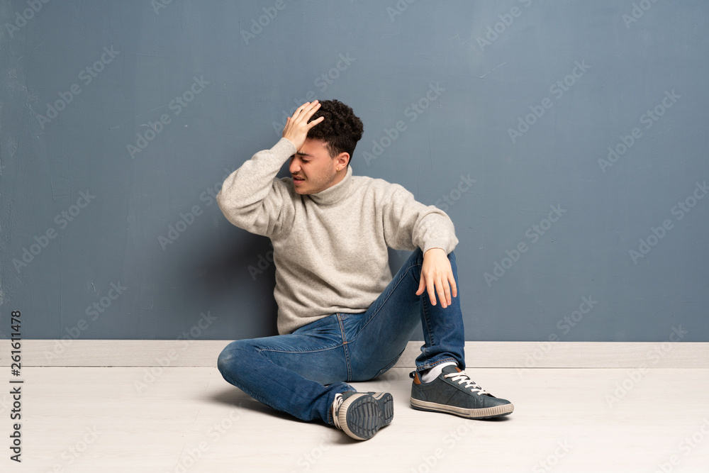 Young man sitting on the floor has realized something and intending the solution Young man sitting on the floor has realized something and intending the solution